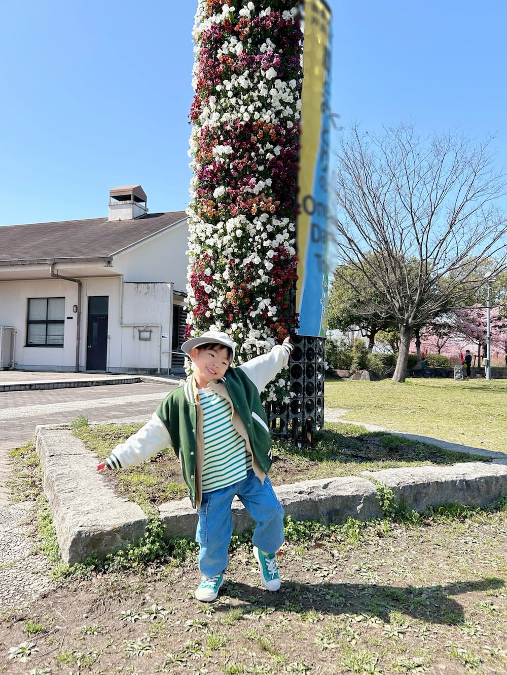 グリーン系のTシャツ/カットソー、ベージュ系のベスト、ブルー系のデニムパンツを着用したキッズの春コーディネートの3枚目の写真