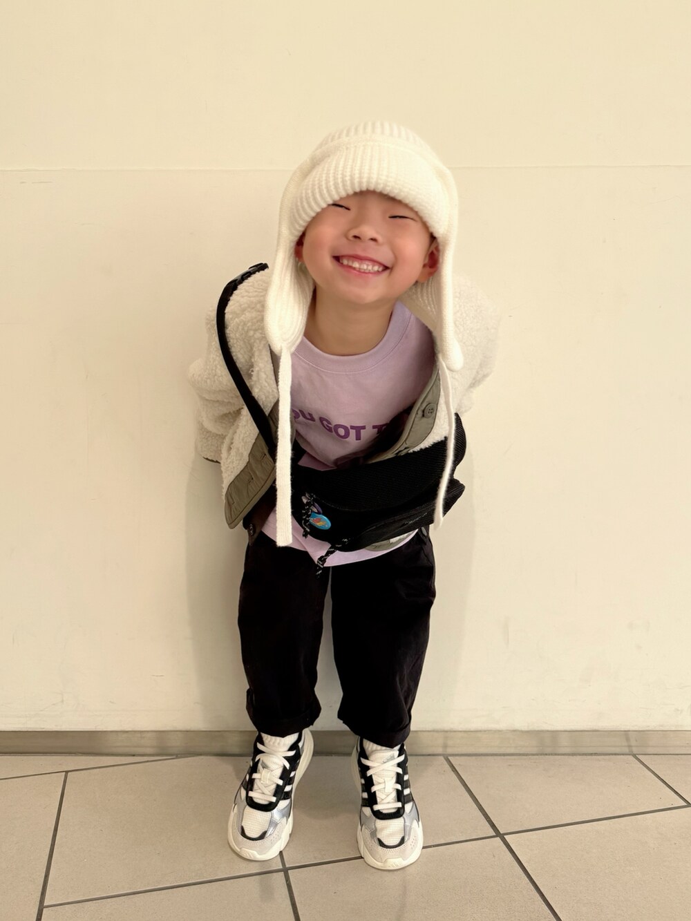 パープル系のTシャツ/カットソー、グリーン系のノーカラージャケット、ブラック系のボディバッグ/ウエストポーチを着用したキッズの冬コーディネートの4枚目の写真