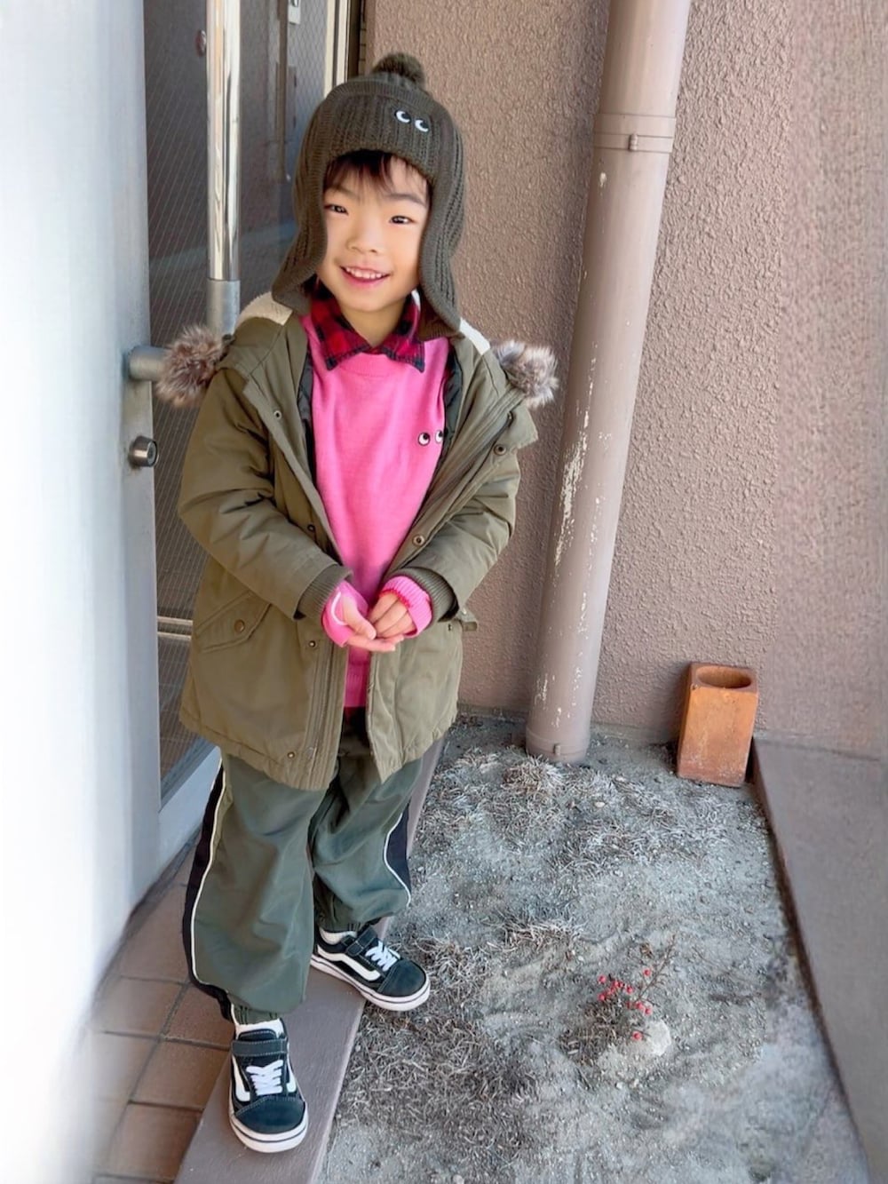 レッド系のシャツ/ブラウス、ピンク系のニット/セーター、グリーン系のモッズコートを着用したキッズの冬コーディネートの2枚目の写真