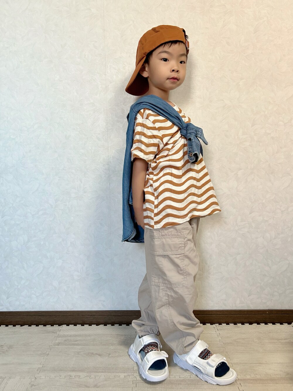 ベージュ系のTシャツ/カットソー、ブルー系のシャツ/ブラウス、ベージュ系のカーゴパンツを着用したキッズの秋コーディネートの4枚目の写真