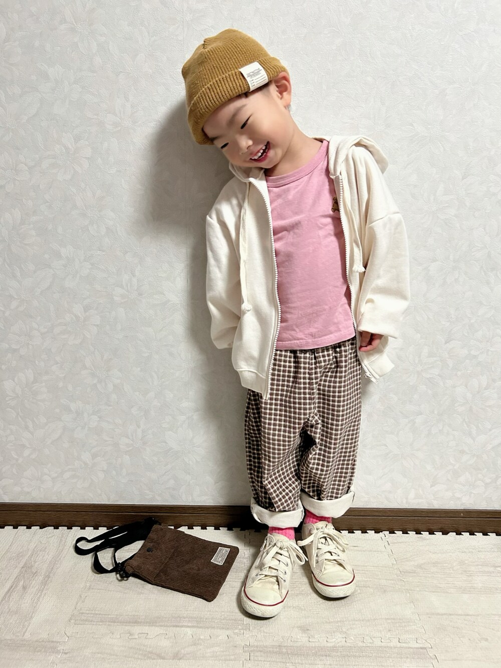 ホワイト系のパーカー、ピンク系のトップス、ブラウン系のパンツを着用したキッズの秋コーディネートの4枚目の写真