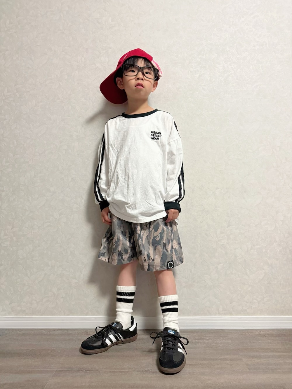 ブラック系のショルダーバッグ、ブラック系のスニーカー、ホワイト系のTシャツ/カットソーを着用したキッズの春コーディネートの4枚目の写真