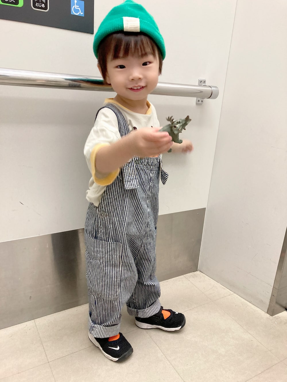 ホワイト系のTシャツ/カットソー、グリーン系のカーディガン/ボレロ、ブラック系のスニーカーを着用したキッズの秋コーディネートの4枚目の写真