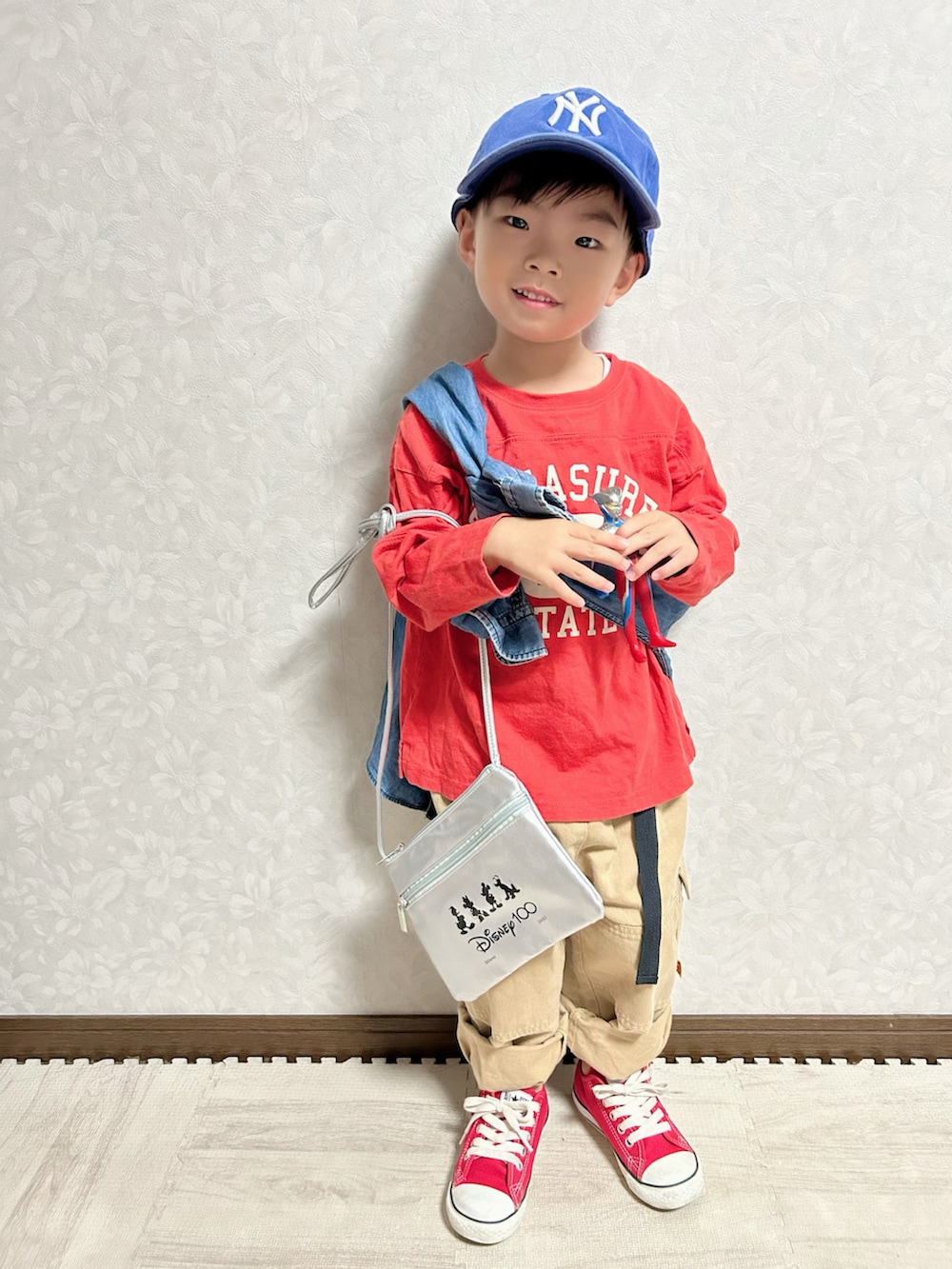 レッド系のTシャツ/カットソー、ブルー系のシャツ/ブラウス、ベージュ系のカーゴパンツを着用したキッズの秋コーディネートの2枚目の写真