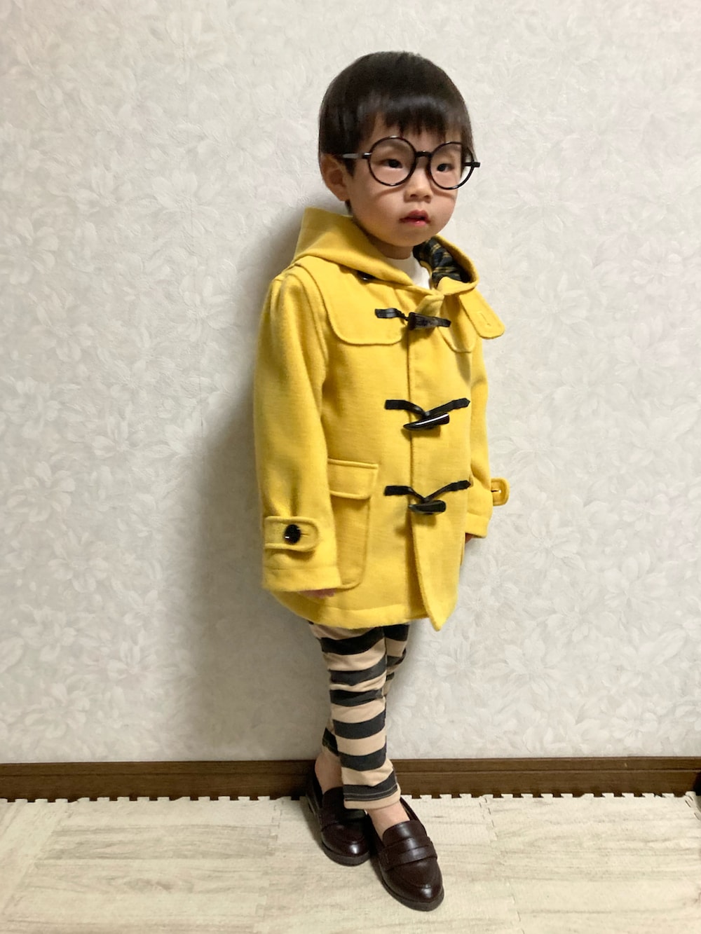 ホワイト系のニット/セーター、イエロー系のダッフルコート、ブラック系のその他パンツを着用したキッズの冬コーディネートの4枚目の写真