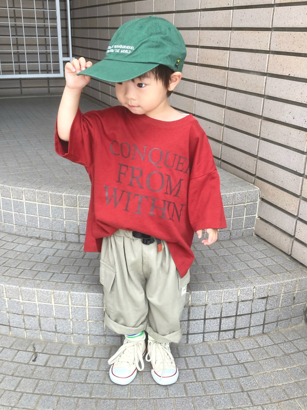 レッド系のTシャツ/カットソー、グリーン系のスウェットパンツ、グリーン系のキャップを着用したキッズの夏コーディネートの2枚目の写真