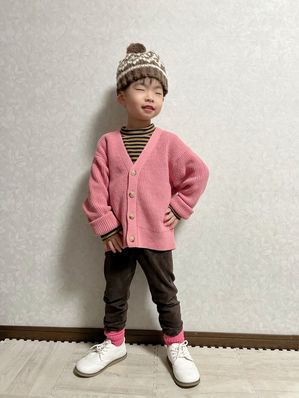 ピンク系のカーディガン/ボレロ、ブラウン系のTシャツ/カットソー、ホワイト系のドレスシューズを着用したキッズの冬コーディネートの2枚目の写真