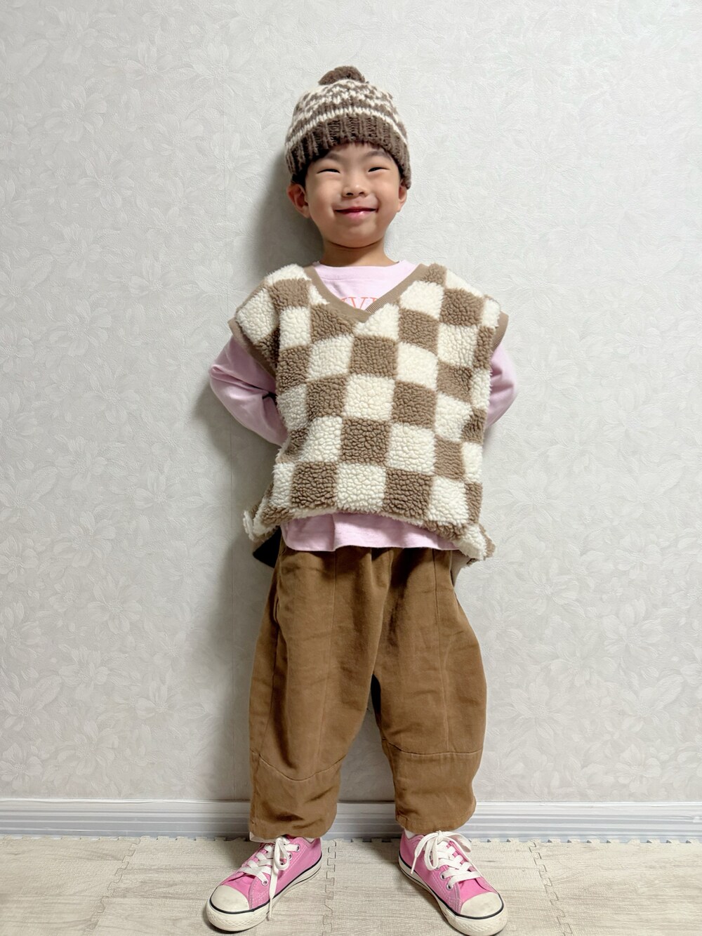 ピンク系のTシャツ/カットソー、ブラウン系のベスト、ブラウン系のショルダーバッグを着用したキッズの冬コーディネートの5枚目の写真