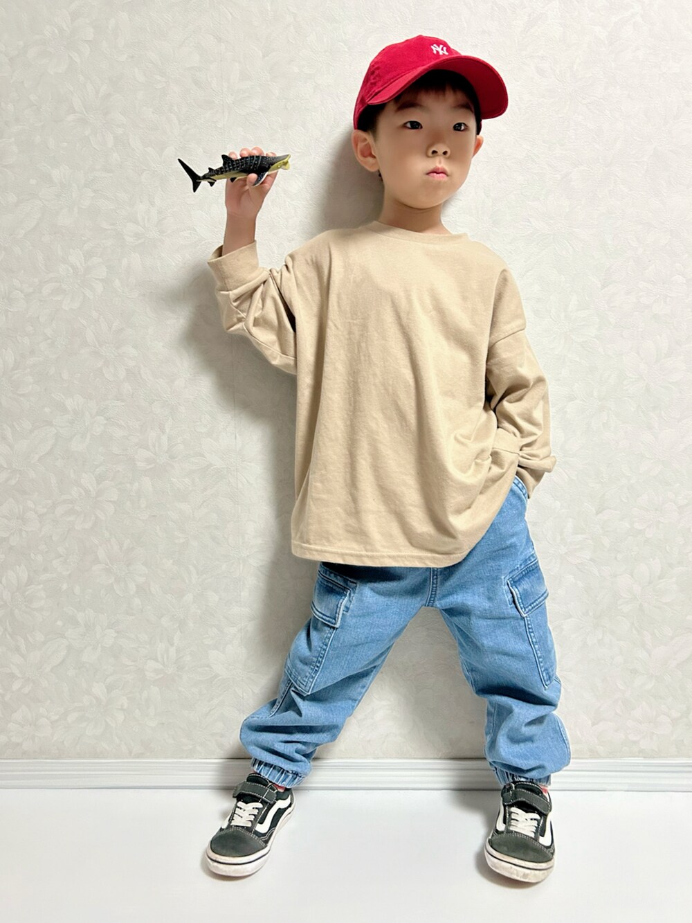 ベージュ系のTシャツ/カットソー、ブラウン系のカーディガン/ボレロ、ブルー系のデニムパンツを着用したキッズの秋コーディネートの2枚目の写真