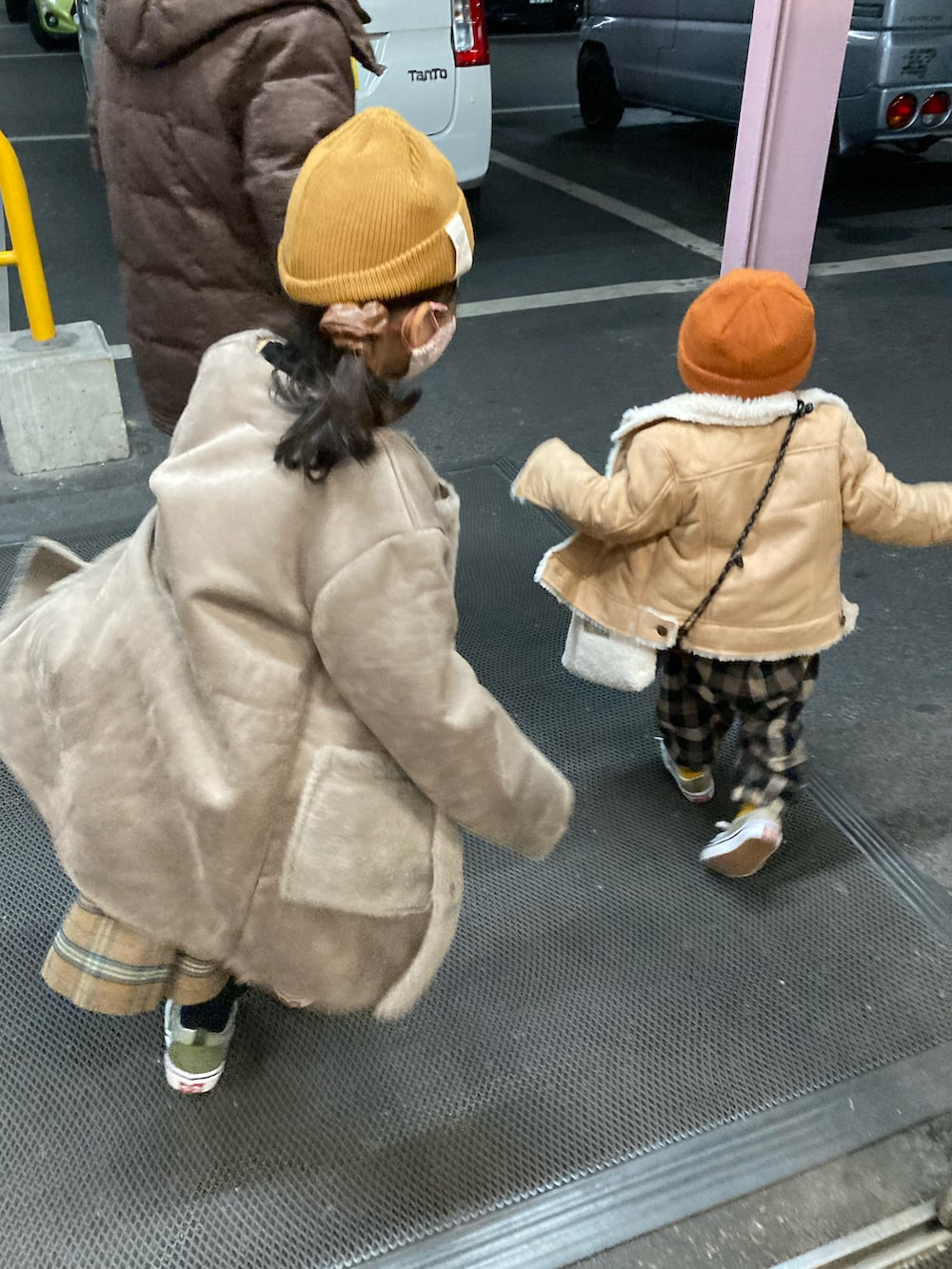 イエロー系のニット/セーター、ホワイト系のニット/セーター、ベージュ系のジャケット/アウターを着用したキッズの冬コーディネートの5枚目の写真