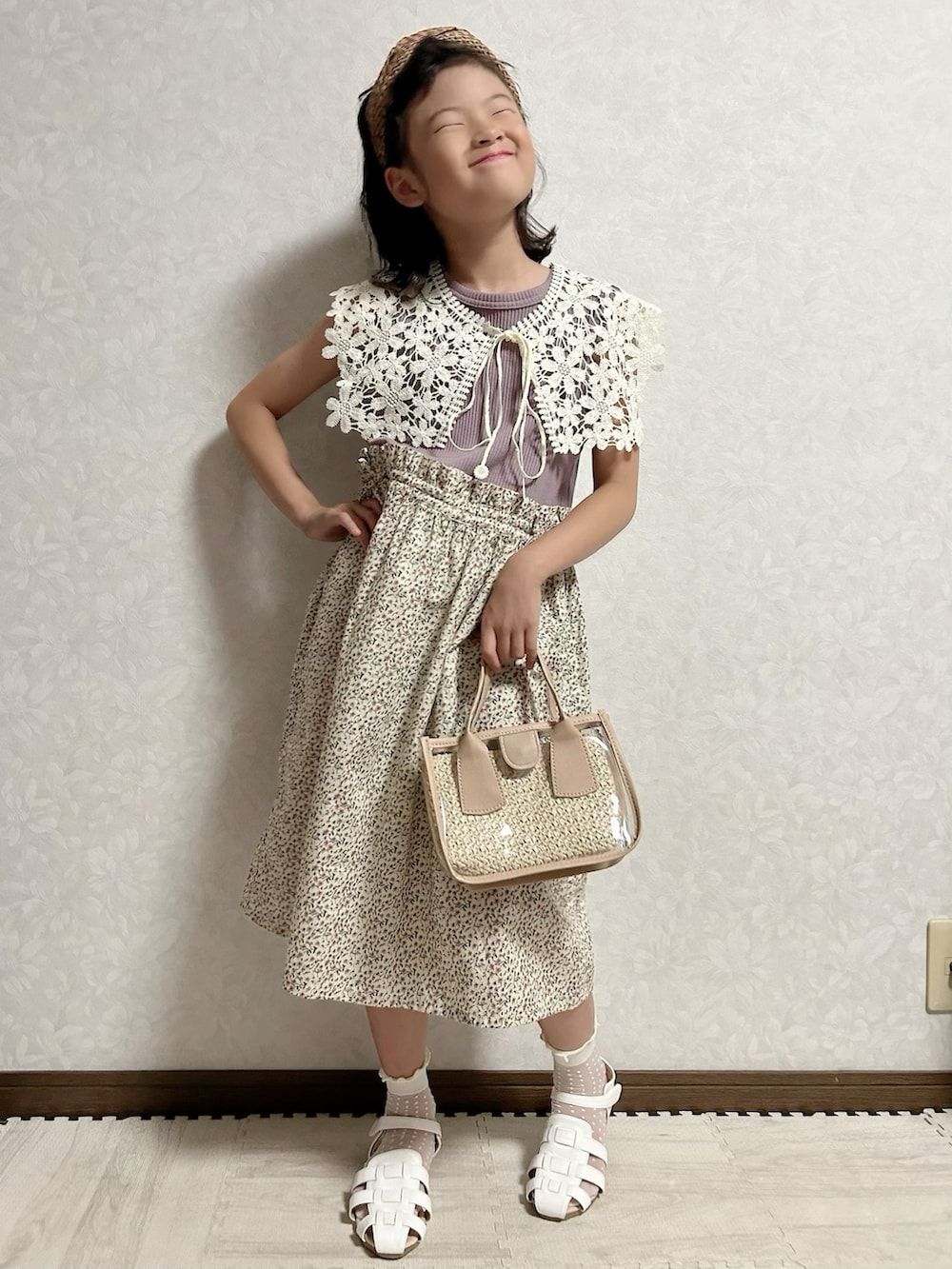 パープル系のワンピース、グリーン系のショルダーバッグ、ホワイト系のサンダルを着用したキッズの夏コーディネートの2枚目の写真