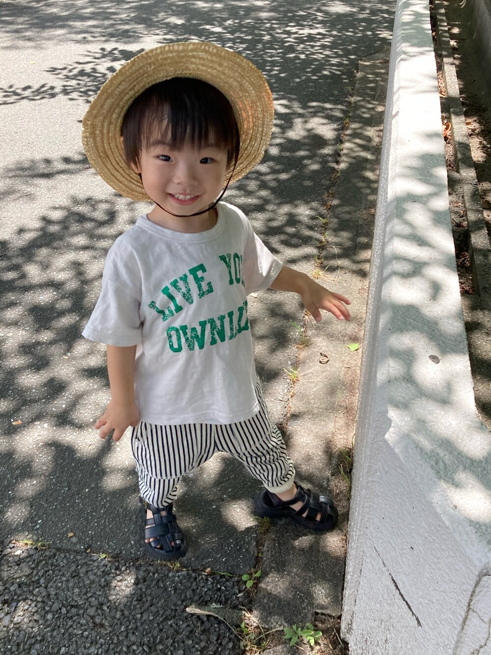 ベージュ系のTシャツ/カットソー、ブルー系のその他パンツ、ブラック系のサンダルを着用したキッズの夏コーディネートの5枚目の写真