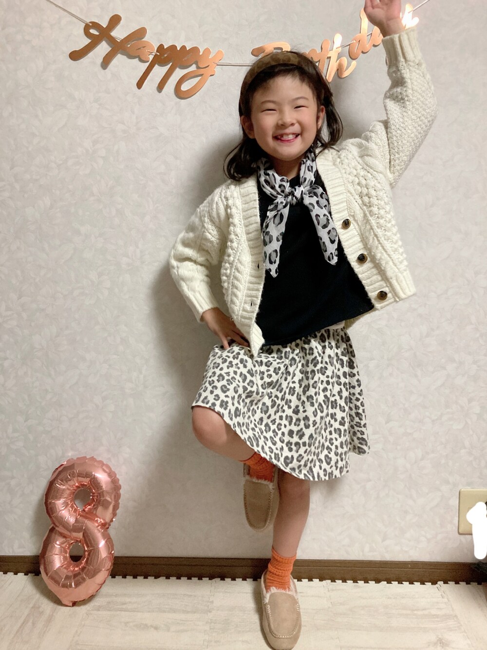 ブラック系のTシャツ/カットソー、ホワイト系のカーディガン/ボレロ、ベージュ系のスカートを着用したキッズの秋コーディネートの5枚目の写真