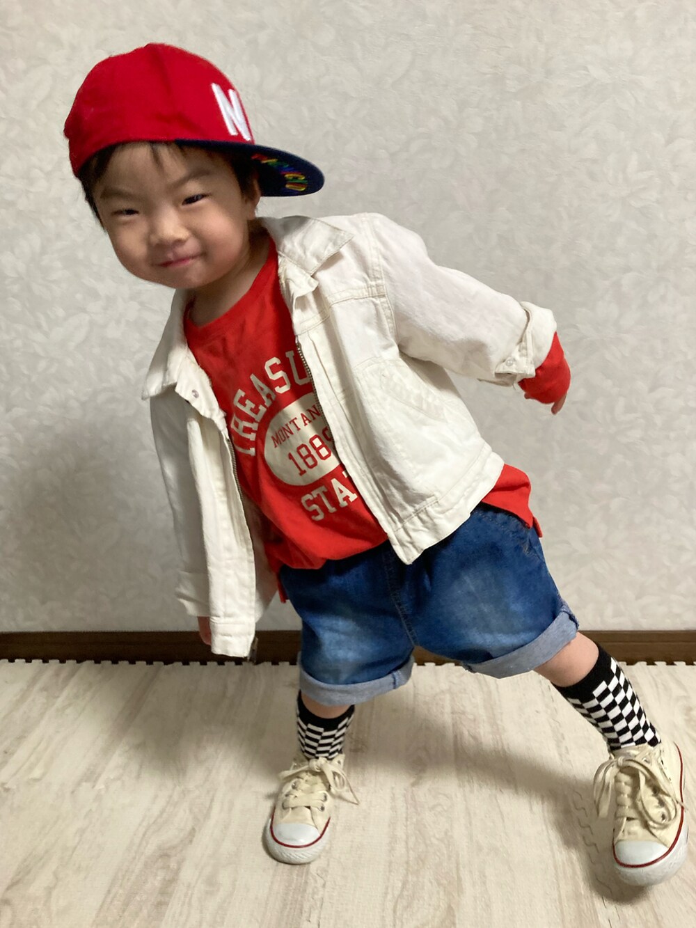 ホワイト系のデニムジャケット、レッド系のTシャツ/カットソー、ブルー系のデニムパンツを着用したキッズの春コーディネートの2枚目の写真