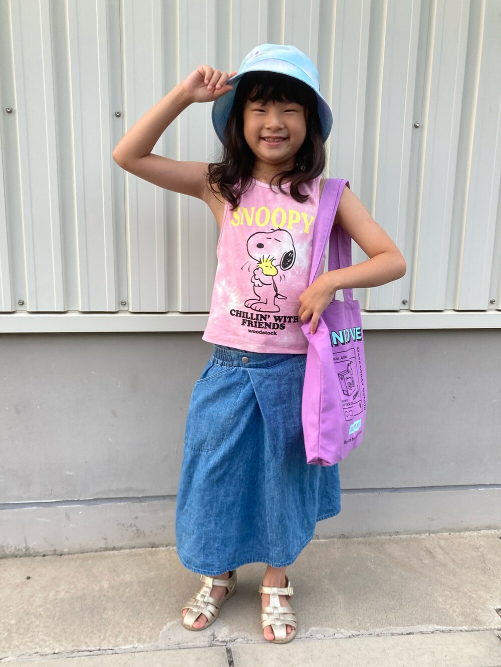 パープル系のトートバッグ、ピンク系のタンクトップ、ブルー系のパンツを着用したキッズの夏コーディネートの4枚目の写真