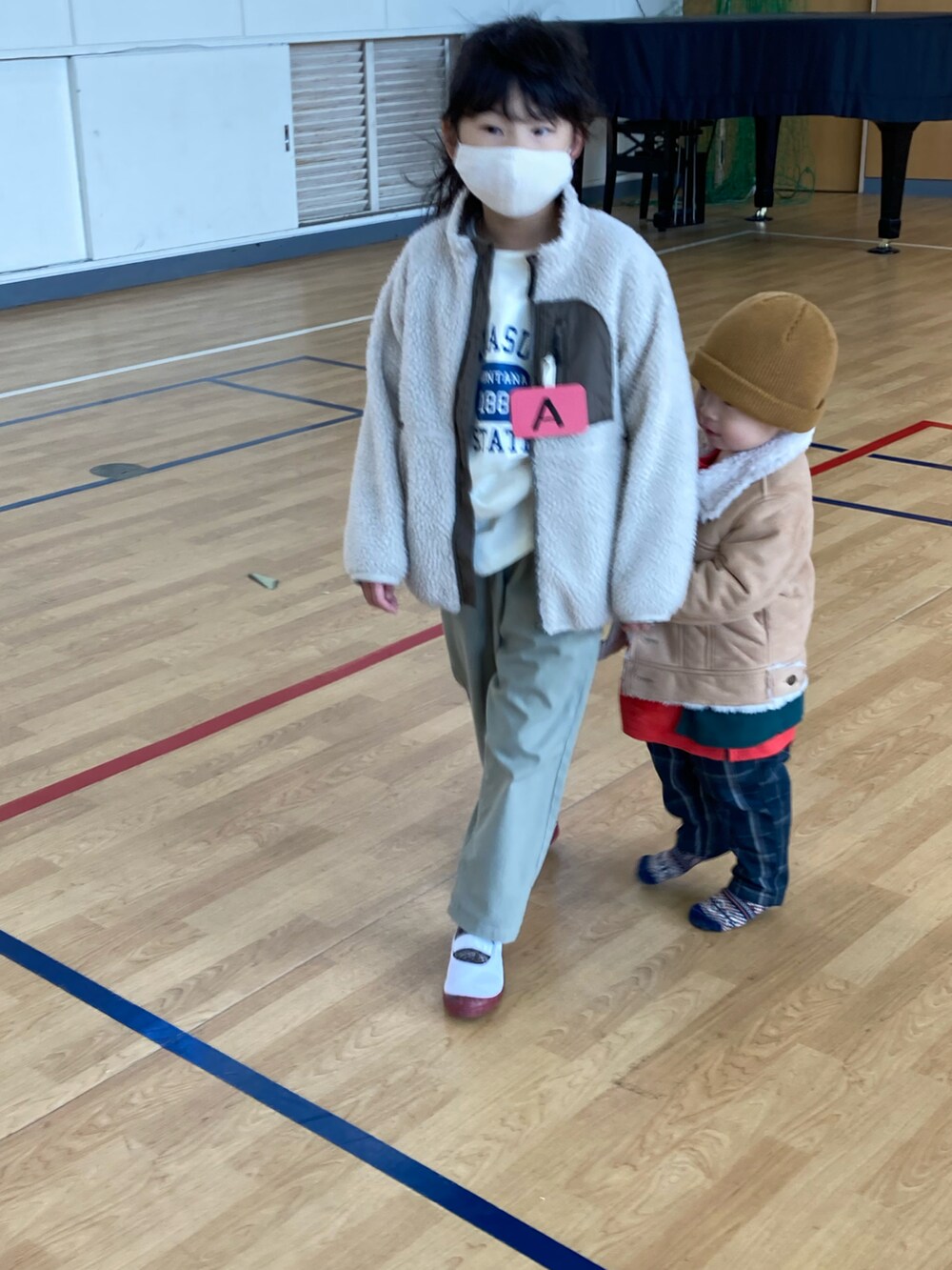 レッド系のTシャツ/カットソー、ホワイト系のTシャツ/カットソー、ベージュ系のジャケット/アウターを着用したキッズの冬コーディネートの4枚目の写真