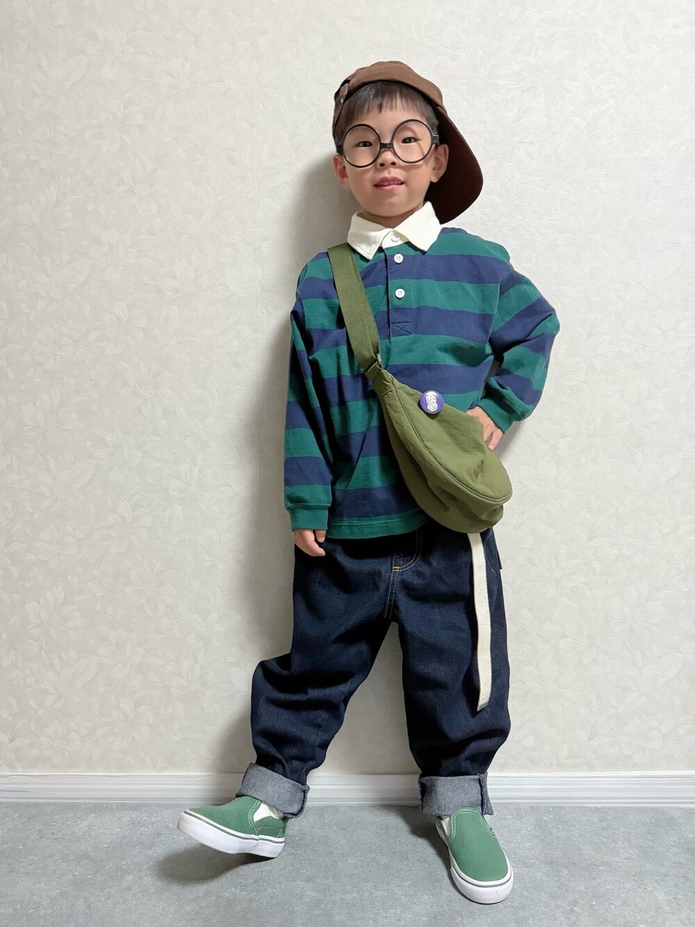 グリーン系のスリッポン、グリーン系のポロシャツ、ブルー系のデニムパンツを着用したキッズの秋コーディネートの2枚目の写真