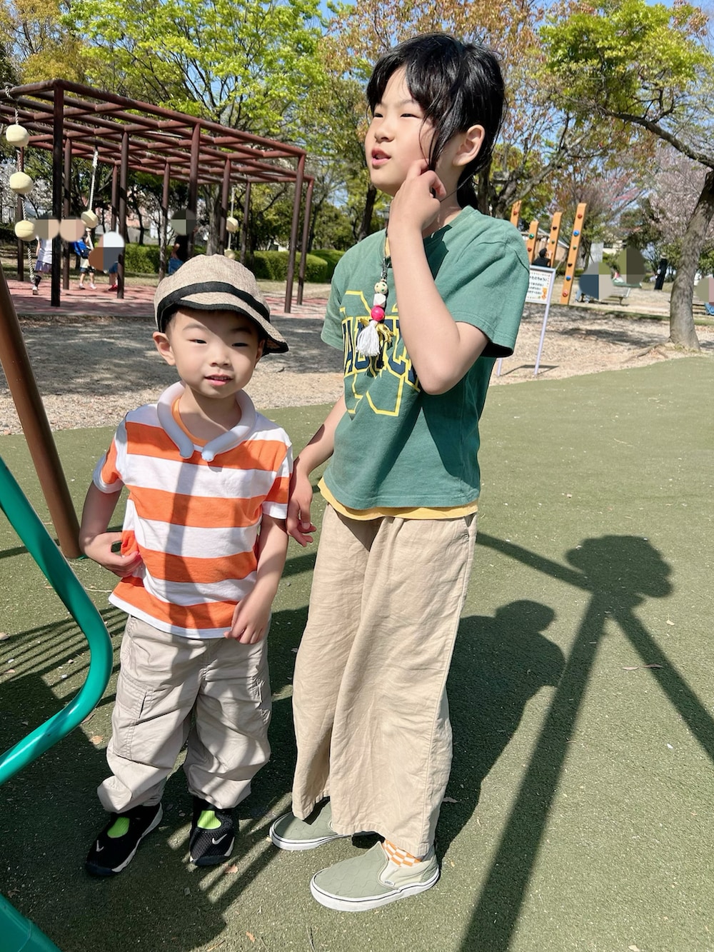 グリーン系のタンクトップ、オレンジ系のシャツ/ブラウス、ホワイト系のカーゴパンツを着用したキッズの春コーディネートの3枚目の写真