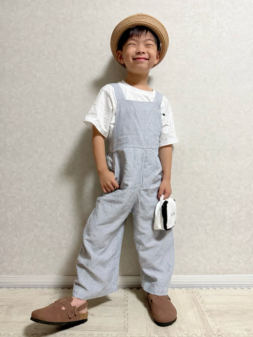 ホワイト系のTシャツ/カットソー、ブルー系のサロペット/オーバーオール、ベージュ系のトートバッグを着用したキッズの夏コーディネートの3枚目の写真