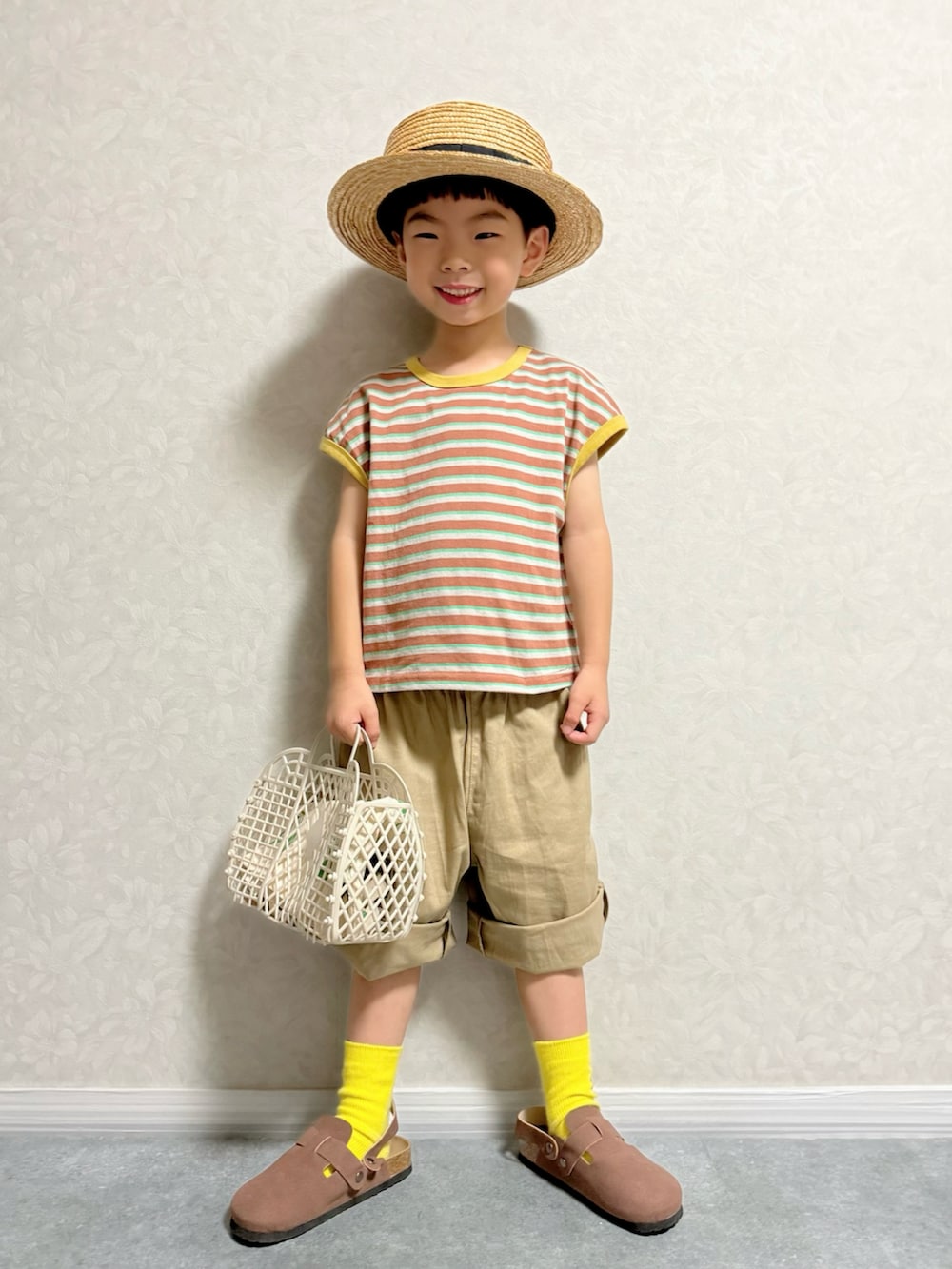 ブラウン系のTシャツ/カットソー、ベージュ系のその他パンツ、ベージュ系のトートバッグを着用したキッズの夏コーディネートの2枚目の写真