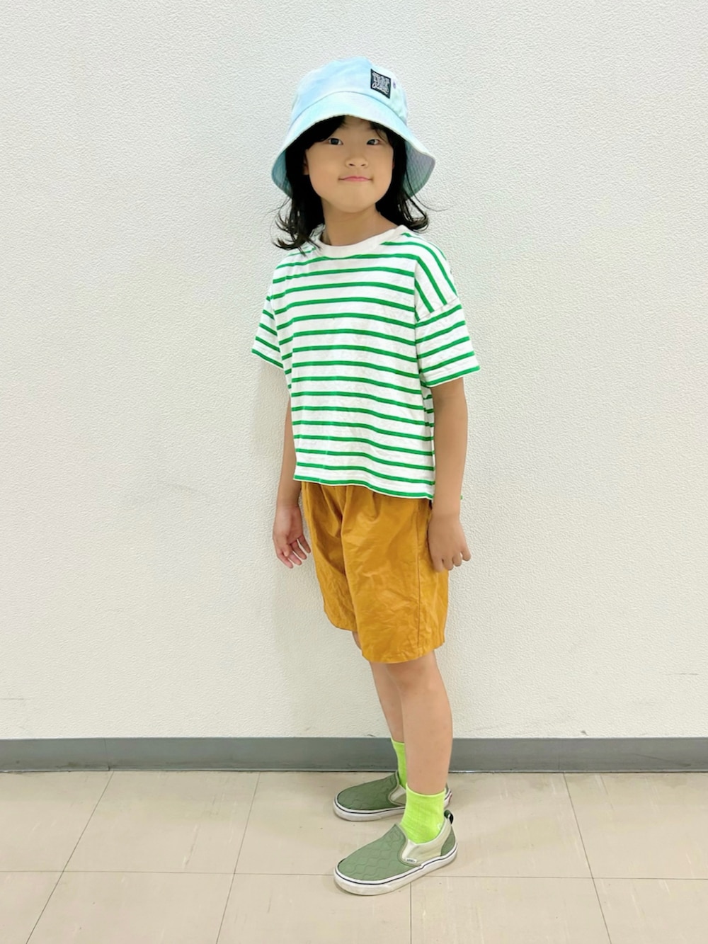 グリーン系のTシャツ/カットソー、イエロー系のその他パンツ、グリーン系のスニーカーを着用したキッズの秋コーディネートの4枚目の写真
