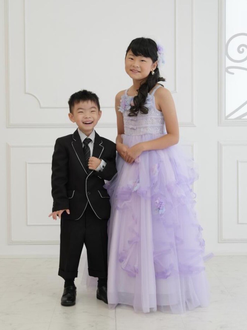 ホワイト系のTシャツ/カットソー、ブラック系のスカート、シルバー系のスリッポンを着用したキッズの秋コーディネートの4枚目の写真