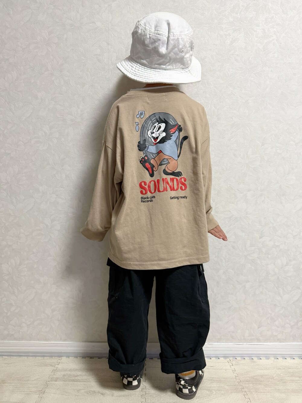 ベージュ系のTシャツ/カットソー、ブラック系のベスト、ブラック系のカーゴパンツを着用したキッズの春コーディネートの3枚目の写真