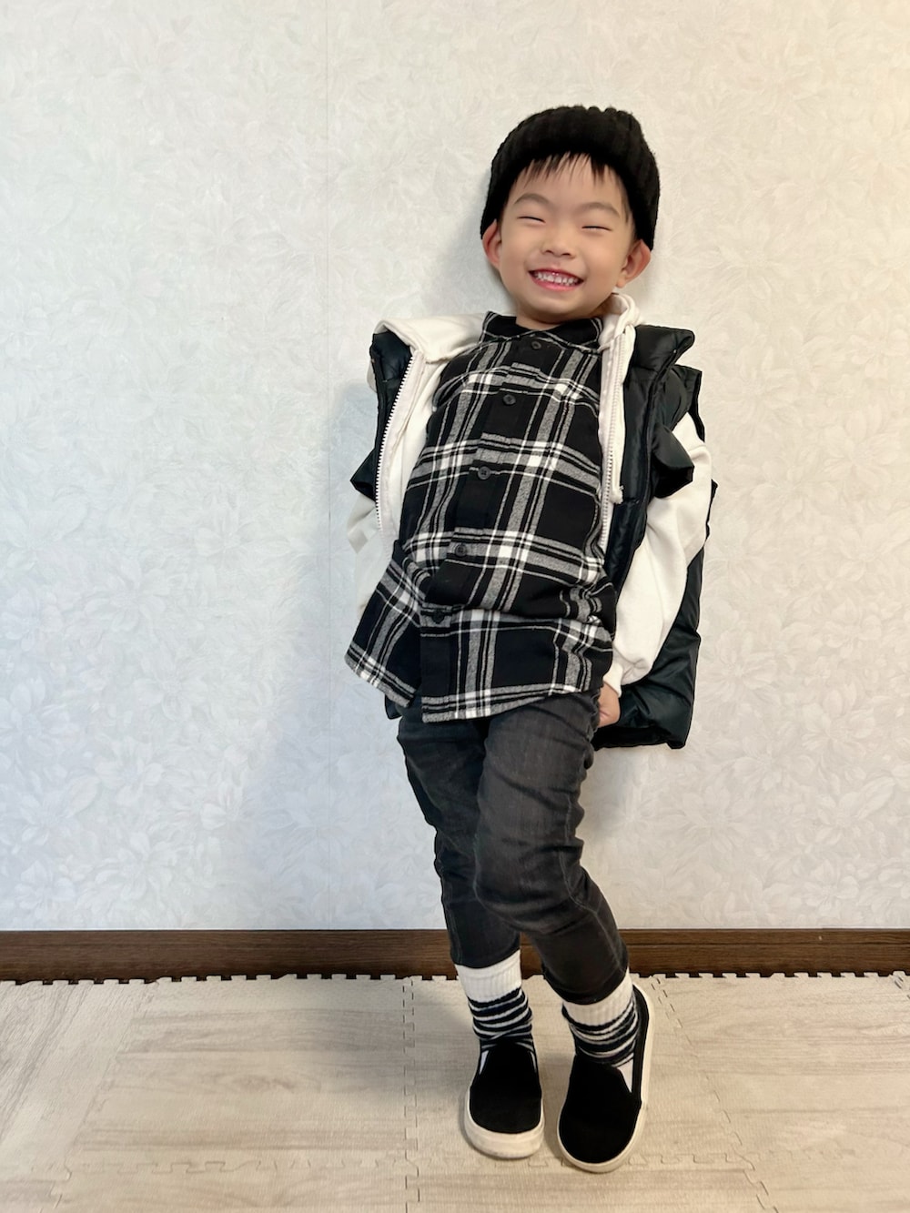 ブラック系のシャツ/ブラウス、ホワイト系のパーカー、ブラック系のダウンベストを着用したキッズの秋コーディネートの4枚目の写真