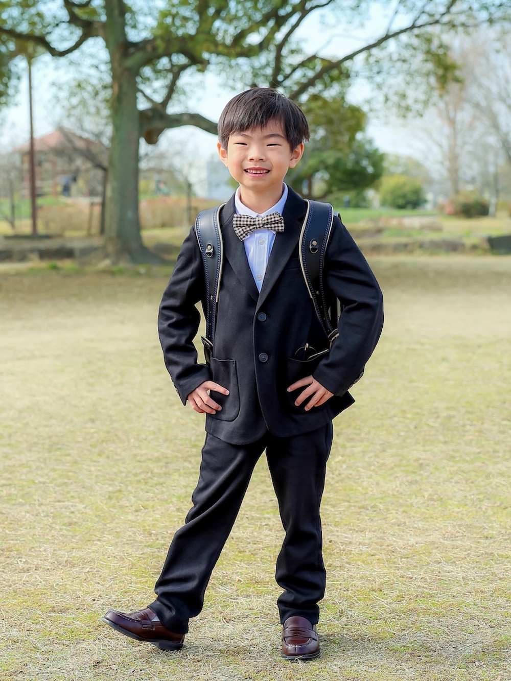 ブラック系のランドセル、ブラウン系のローファー、ホワイト系のシャツ/ブラウスを着用したキッズの冬コーディネートの2枚目の写真