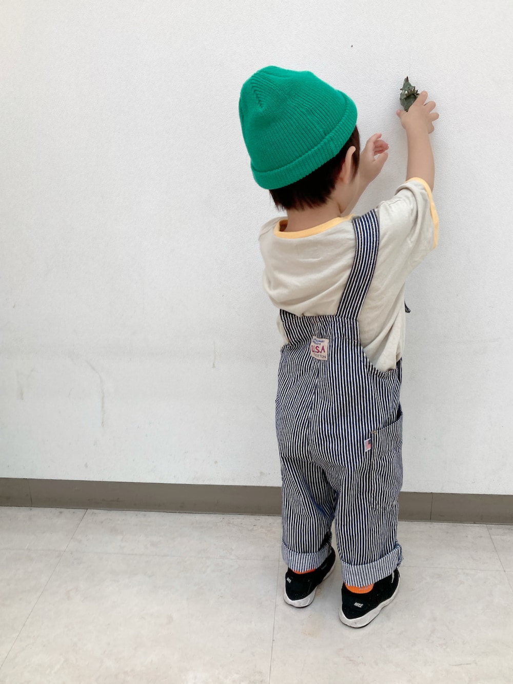 ホワイト系のTシャツ/カットソー、グリーン系のカーディガン/ボレロ、ブラック系のスニーカーを着用したキッズの秋コーディネートの3枚目の写真