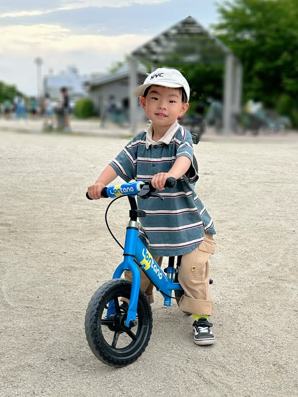 グリーン系のポロシャツ、ブラック系のスニーカー、ベージュ系のカーゴパンツを着用したキッズの夏コーディネートの4枚目の写真