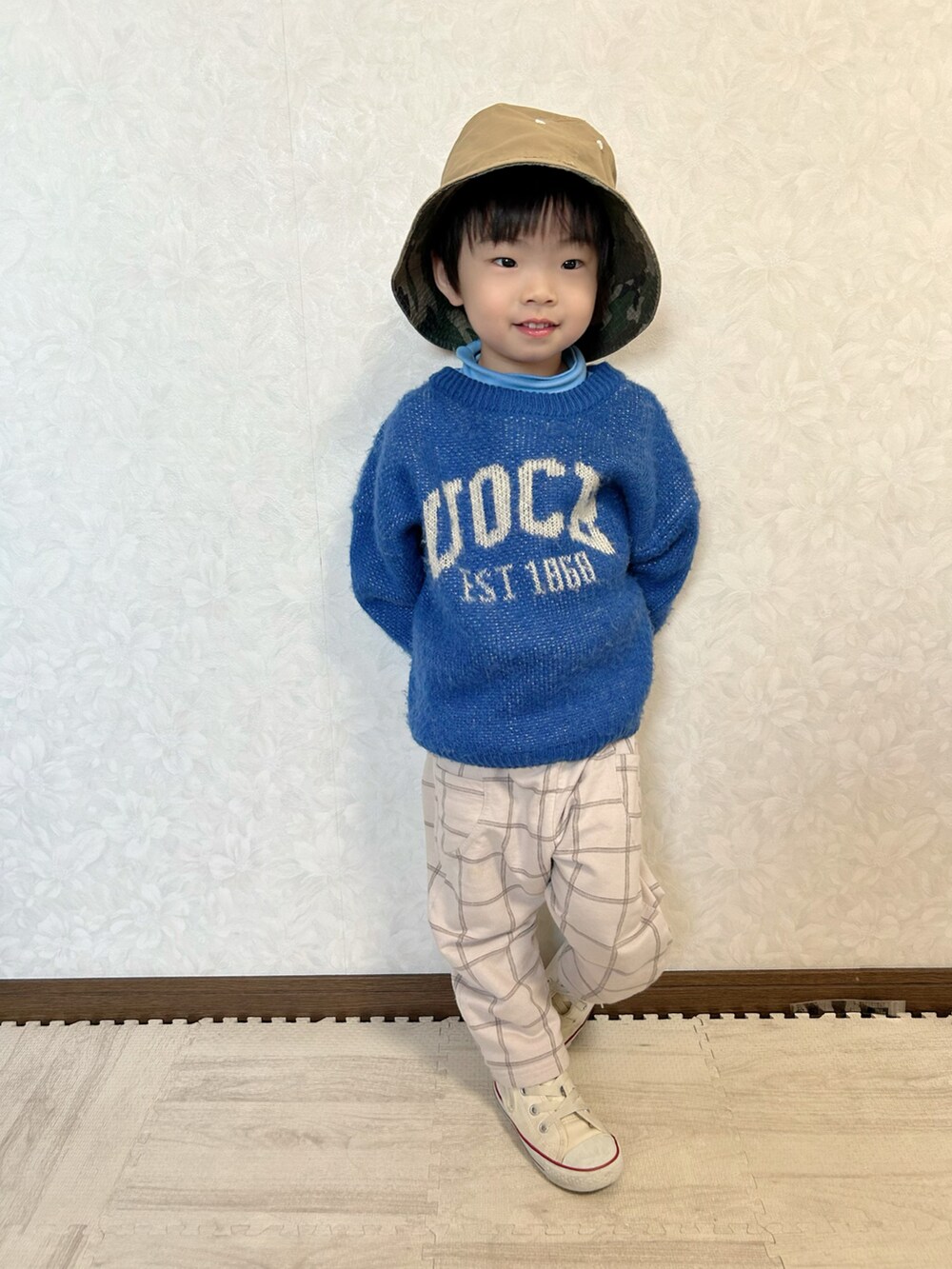 ブルー系のTシャツ/カットソー、ブルー系のニット/セーター、ベージュ系のパンツを着用したキッズの冬コーディネートの2枚目の写真