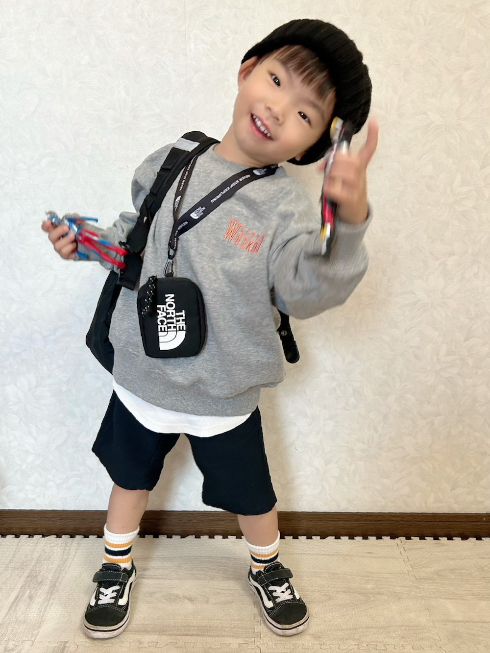 グレー系のスウェット、ブラック系のバックパック/リュック、ブラック系のパンツを着用したキッズの秋コーディネートの2枚目の写真