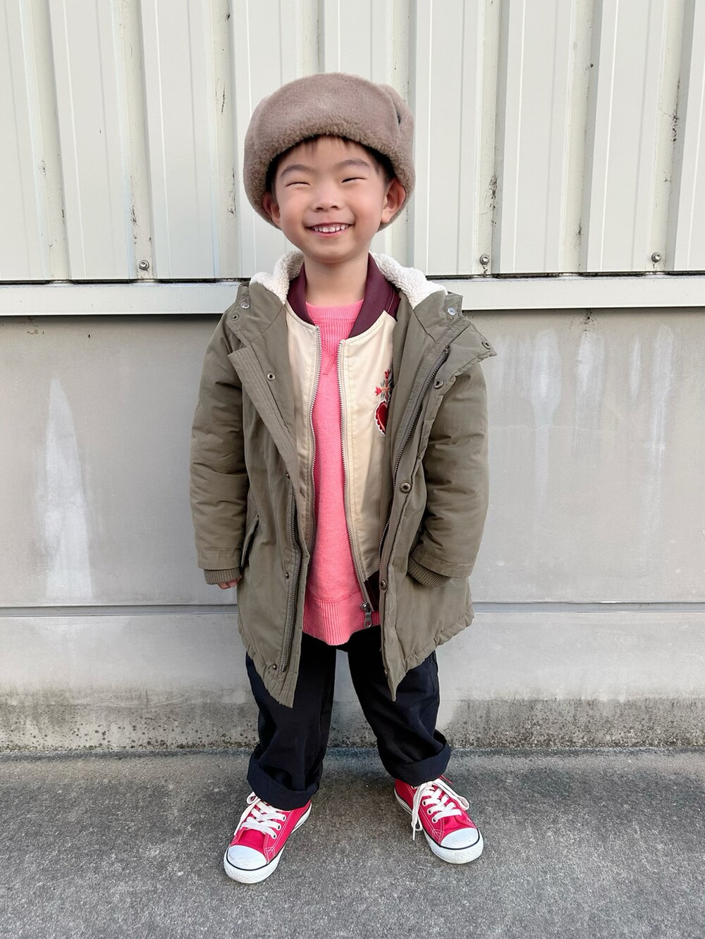 ピンク系のニット/セーター、レッド系のブルゾン、グリーン系のモッズコートを着用したキッズの冬コーディネートの2枚目の写真