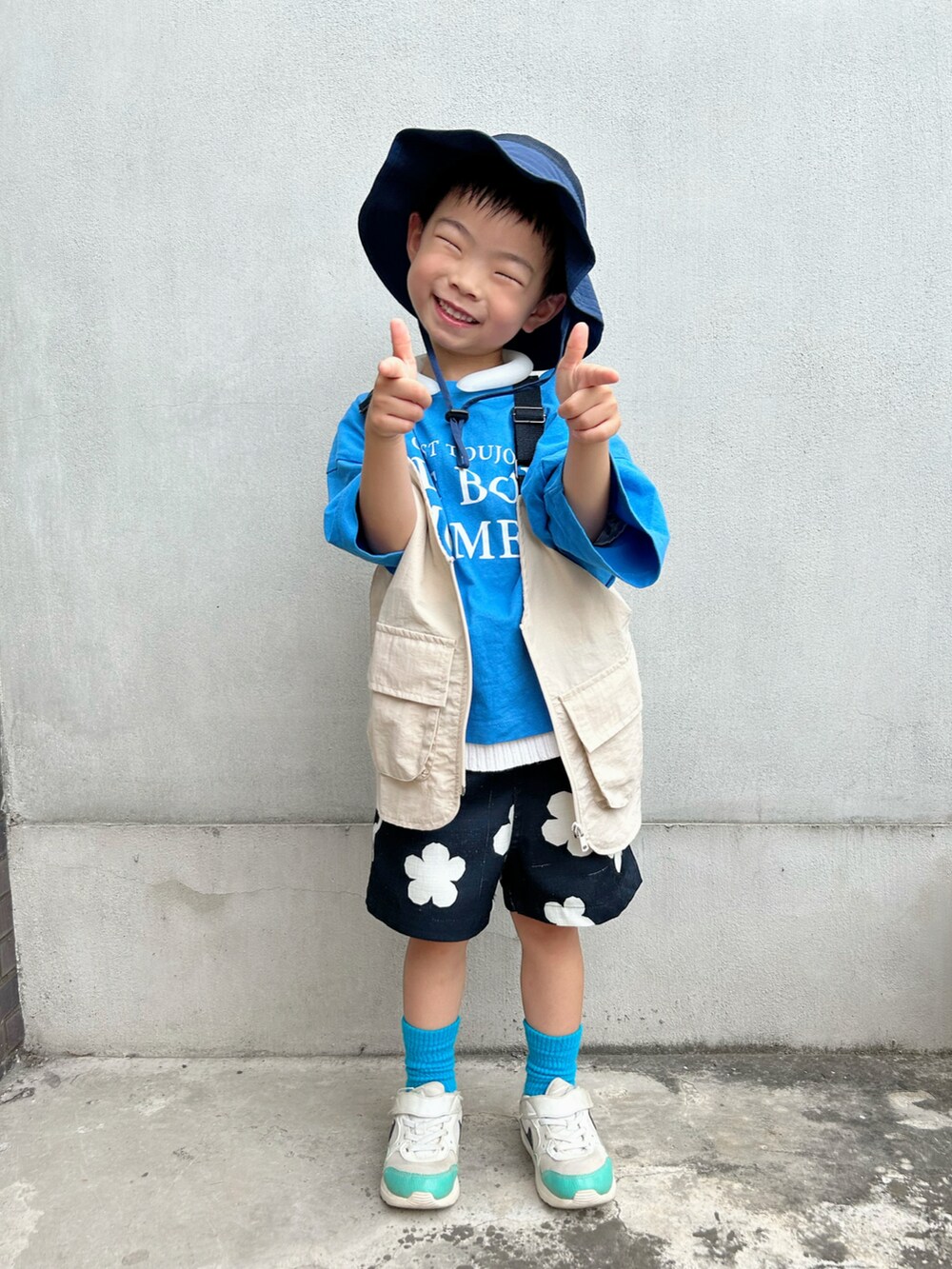 ブルー系のTシャツ/カットソー、ホワイト系のニット/セーター、ベージュ系のベストを着用したキッズの夏コーディネートの2枚目の写真