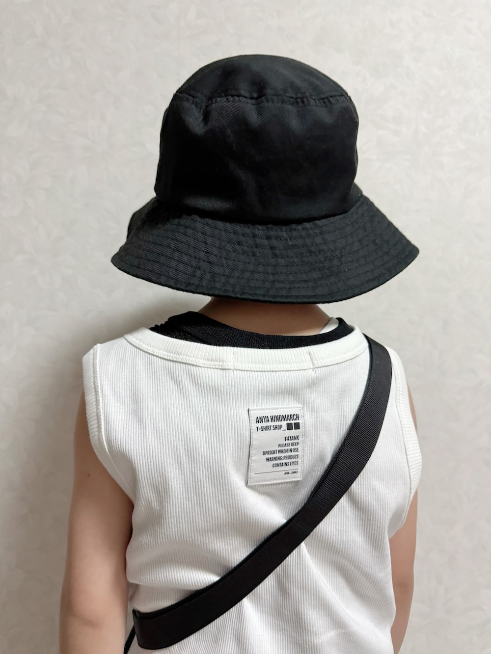 グレー系のパンツ、ブラック系のサンダル、ホワイト系のタンクトップを着用したキッズの夏コーディネートの4枚目の写真