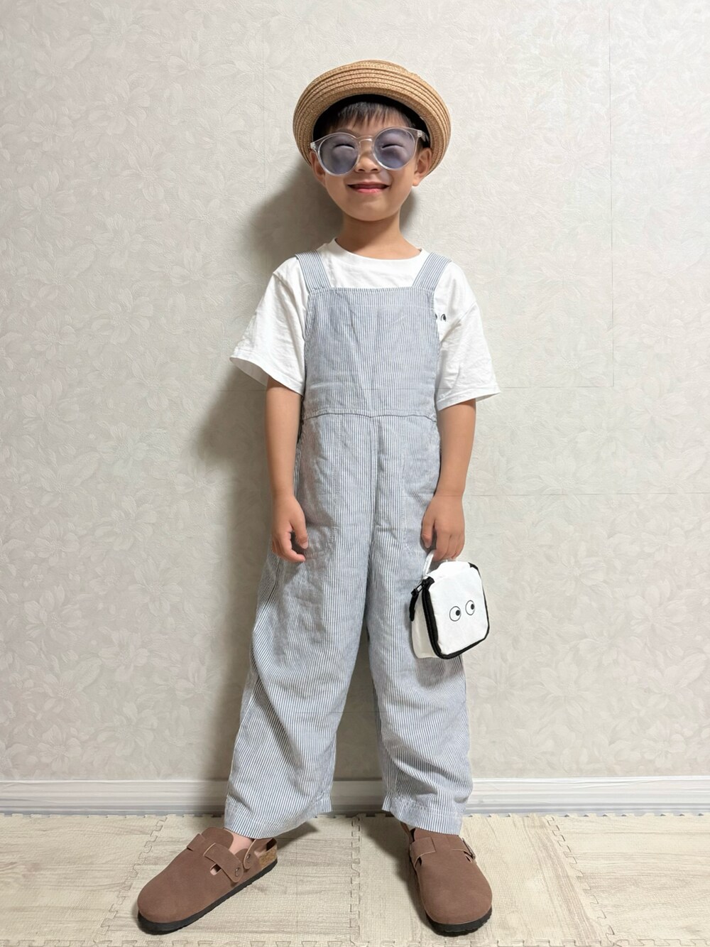 ホワイト系のTシャツ/カットソー、ブルー系のサロペット/オーバーオール、ベージュ系のトートバッグを着用したキッズの夏コーディネートの2枚目の写真