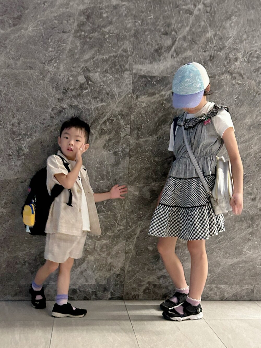 ベージュ系のセットアップ、ホワイト系のTシャツ/カットソー、ブラック系のスニーカーを着用したキッズの秋コーディネートの2枚目の写真