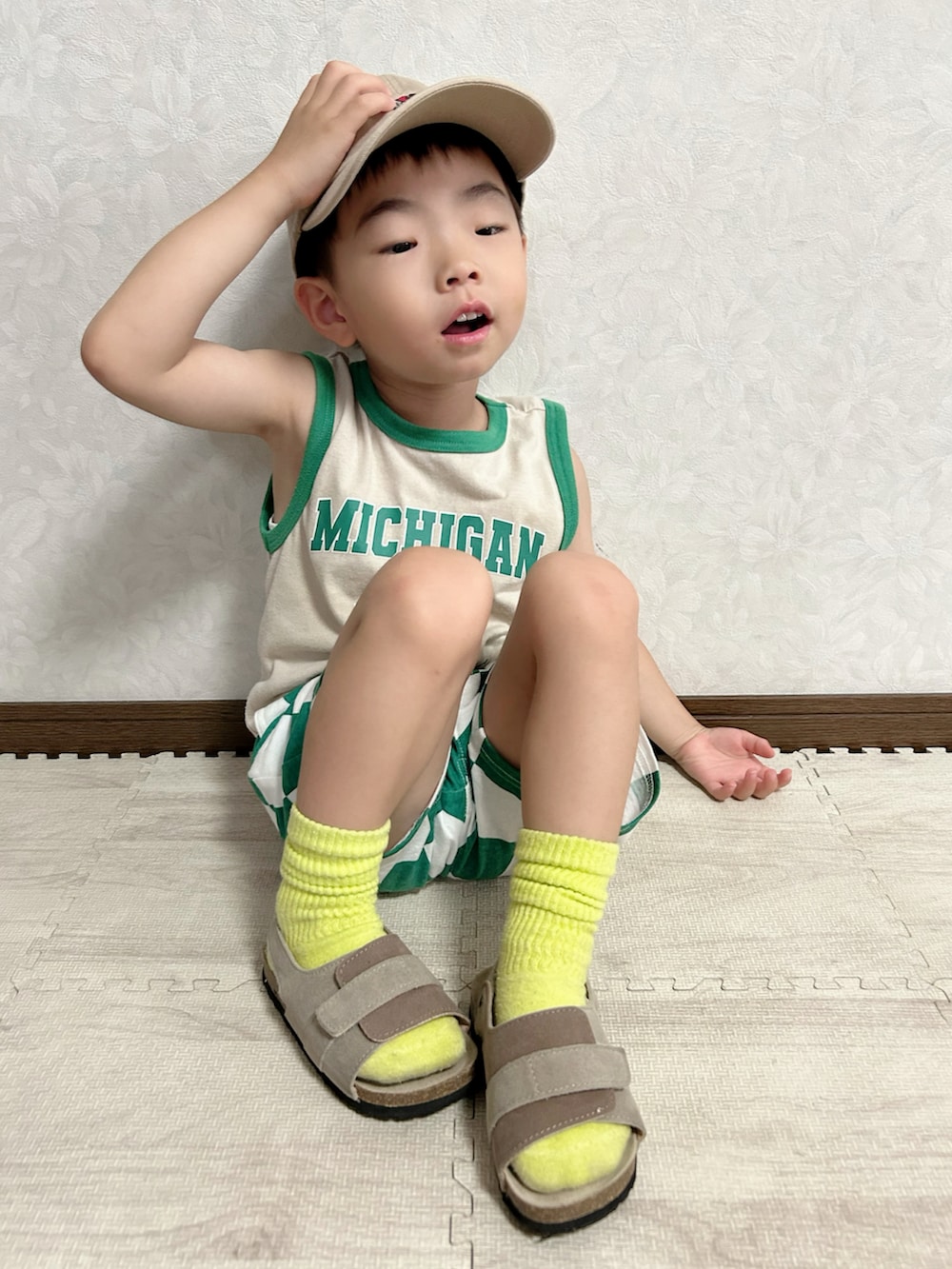 ベージュ系のタンクトップ、グリーン系のパンツ、オレンジ系のショルダーバッグを着用したキッズの夏コーディネートの5枚目の写真