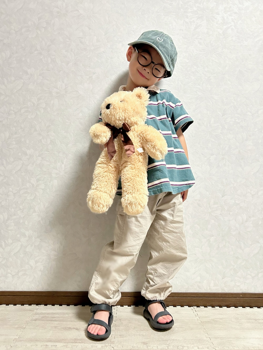 グリーン系のポロシャツ、ベージュ系のカーゴパンツ、ブラック系のサンダルを着用したキッズの夏コーディネートの4枚目の写真