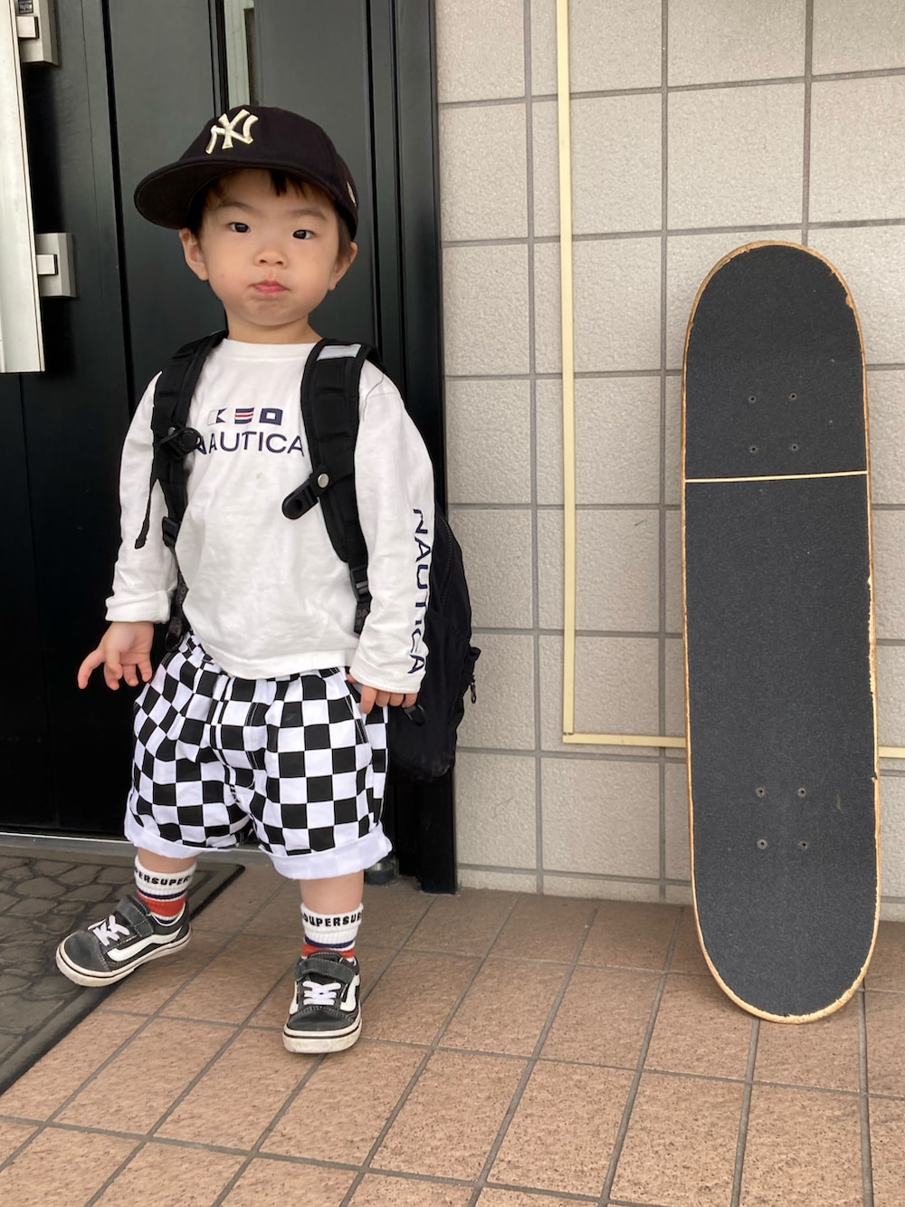 ホワイト系のTシャツ/カットソー、ブラック系のバックパック/リュック、ブラック系のその他パンツを着用したキッズの春コーディネートの2枚目の写真