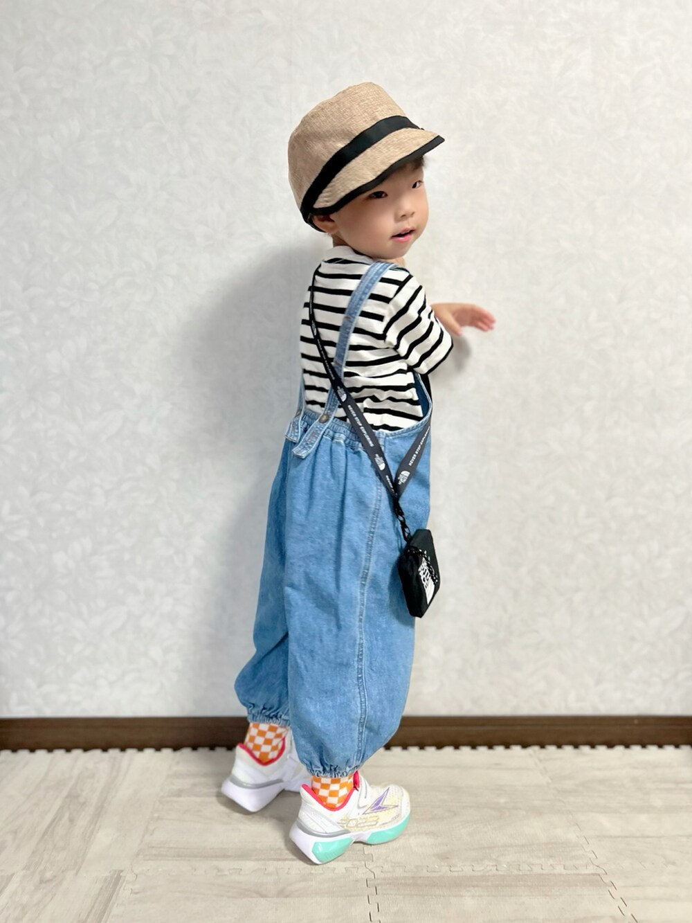 ベージュ系のTシャツ/カットソー、ブルー系のサロペット/オーバーオール、ホワイト系のスニーカーを着用したキッズの秋コーディネートの4枚目の写真