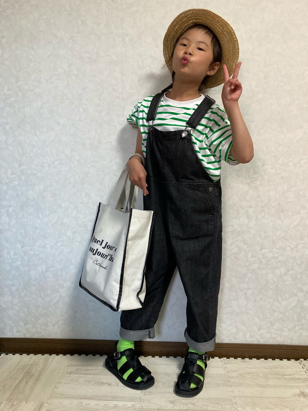 グリーン系のTシャツ/カットソー、ホワイト系のトートバッグ、ブラック系のサロペット/オーバーオールを着用したキッズの春コーディネートの3枚目の写真