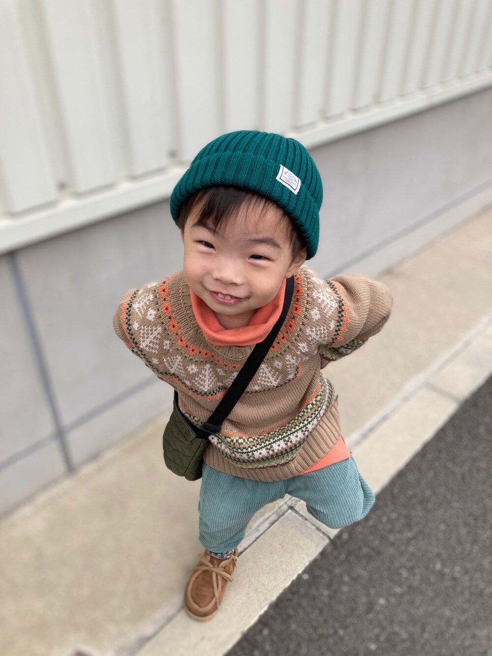 ベージュ系のニット/セーター、オレンジ系のスウェット、グリーン系のその他パンツを着用したキッズの秋コーディネートの5枚目の写真