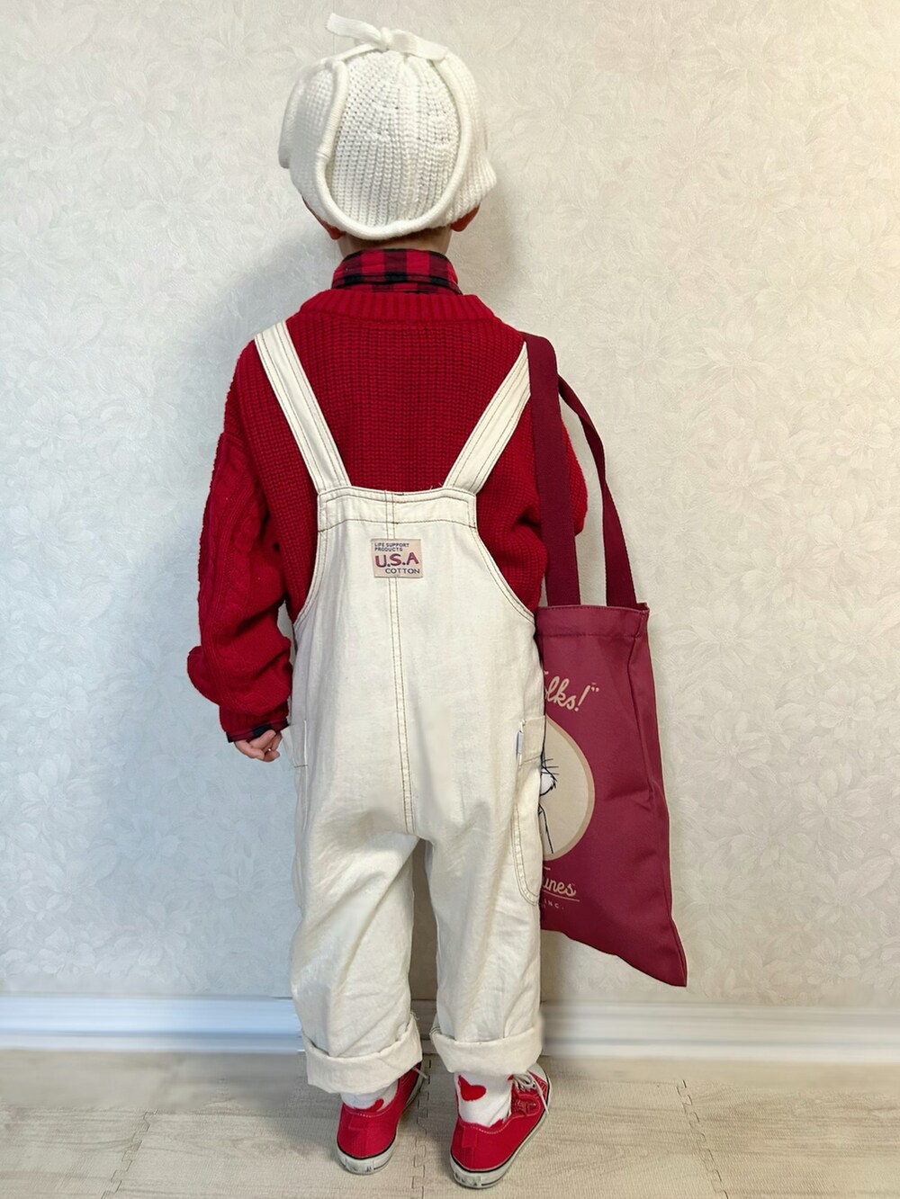 レッド系のシャツ/ブラウス、レッド系のニット/セーター、ホワイト系のサロペット/オーバーオールを着用したキッズの冬コーディネートの5枚目の写真