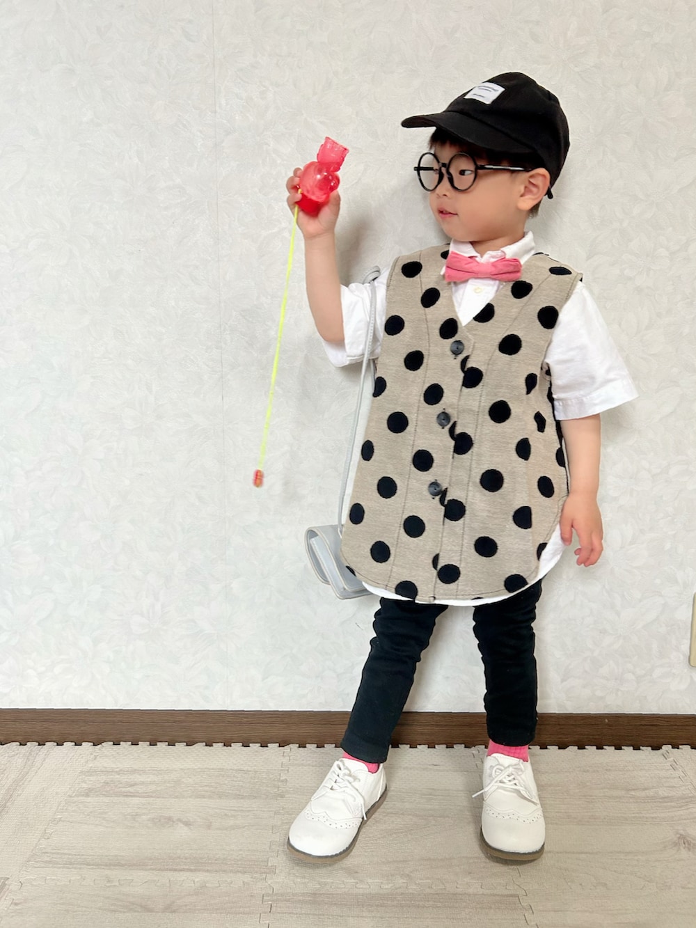 ホワイト系のシャツ/ブラウス、ベージュ系のベスト、レッド系の蝶ネクタイを着用したキッズの春コーディネートの2枚目の写真