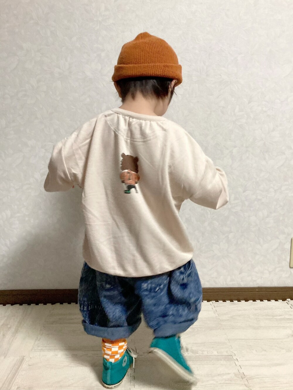 ベージュ系のスウェット、ブルー系のデニムパンツ、ホワイト系のスニーカーを着用したキッズの秋コーディネートの4枚目の写真