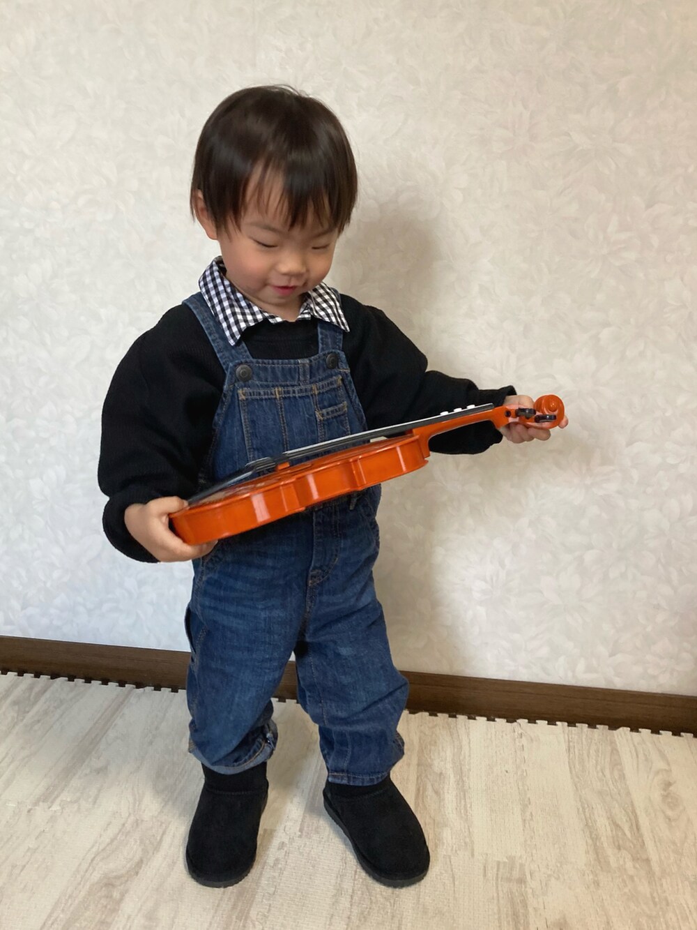 グリーン系のブルゾン、ブルー系のサロペット/オーバーオール、ブルー系のジャンパースカートを着用したキッズの冬コーディネートの3枚目の写真