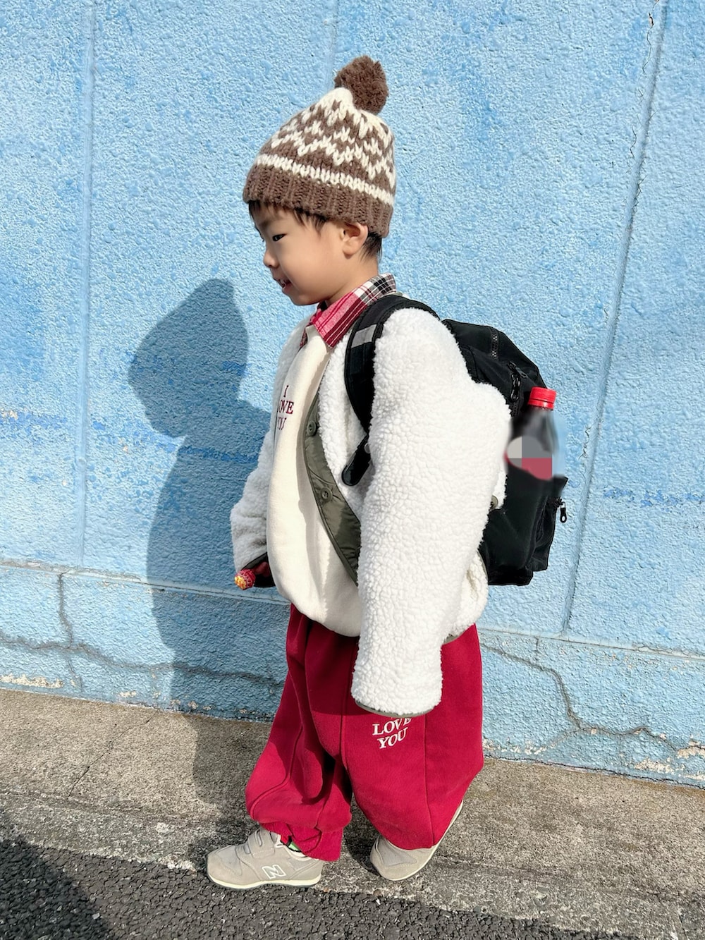 レッド系のセットアップ、レッド系のシャツ/ブラウス、グリーン系のノーカラージャケットを着用したキッズの冬コーディネートの3枚目の写真