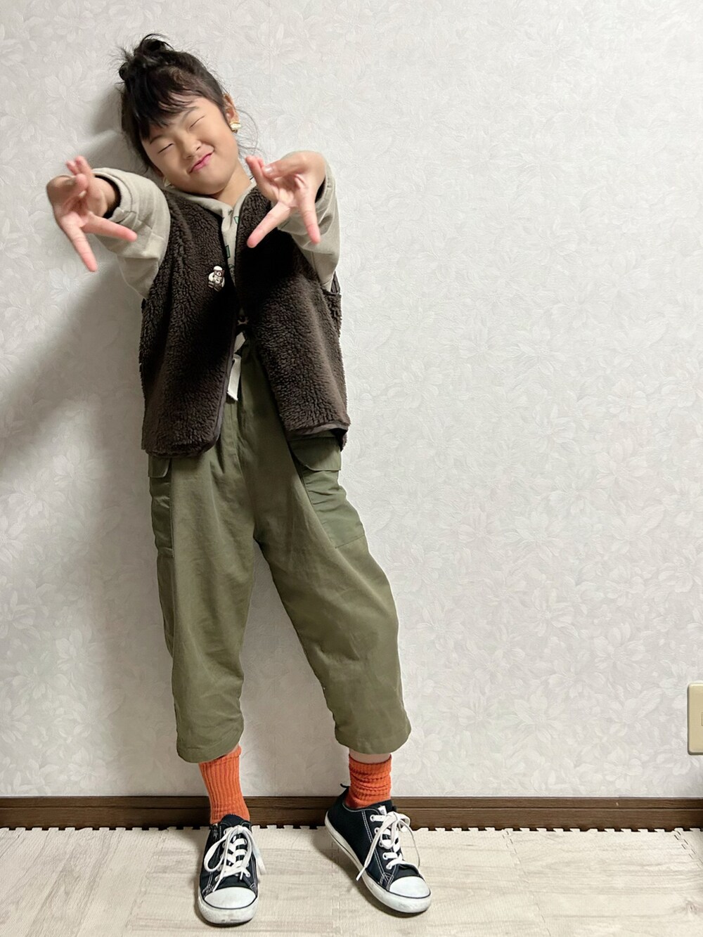 ベージュ系のパーカー、グリーン系のスウェット、グリーン系のサロペット/オーバーオールを着用したキッズの冬コーディネートの2枚目の写真